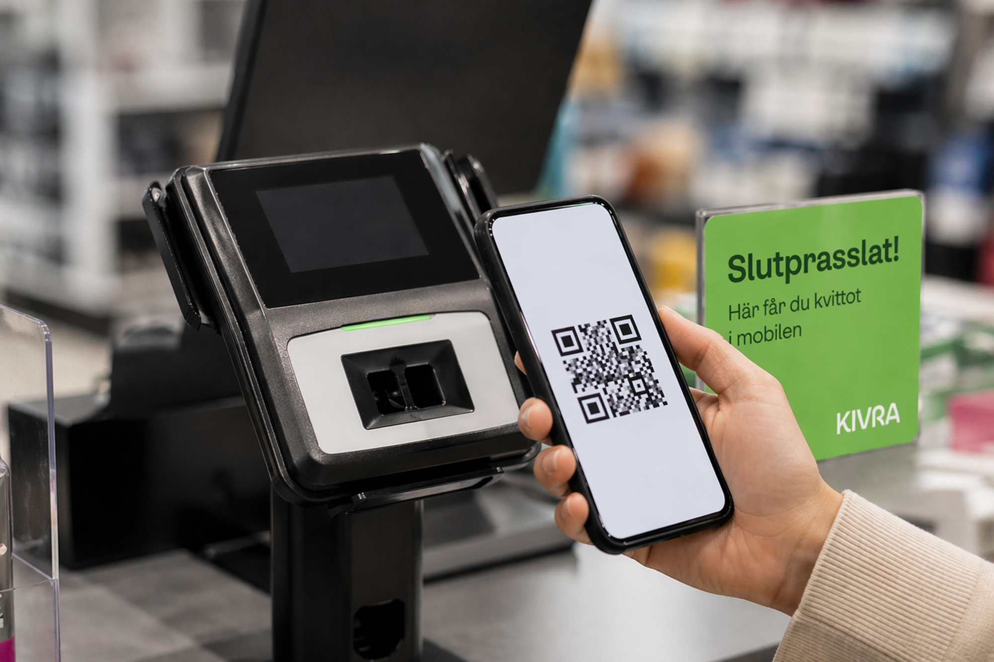 Kvinna håller i sin telefon med en qr-kod på