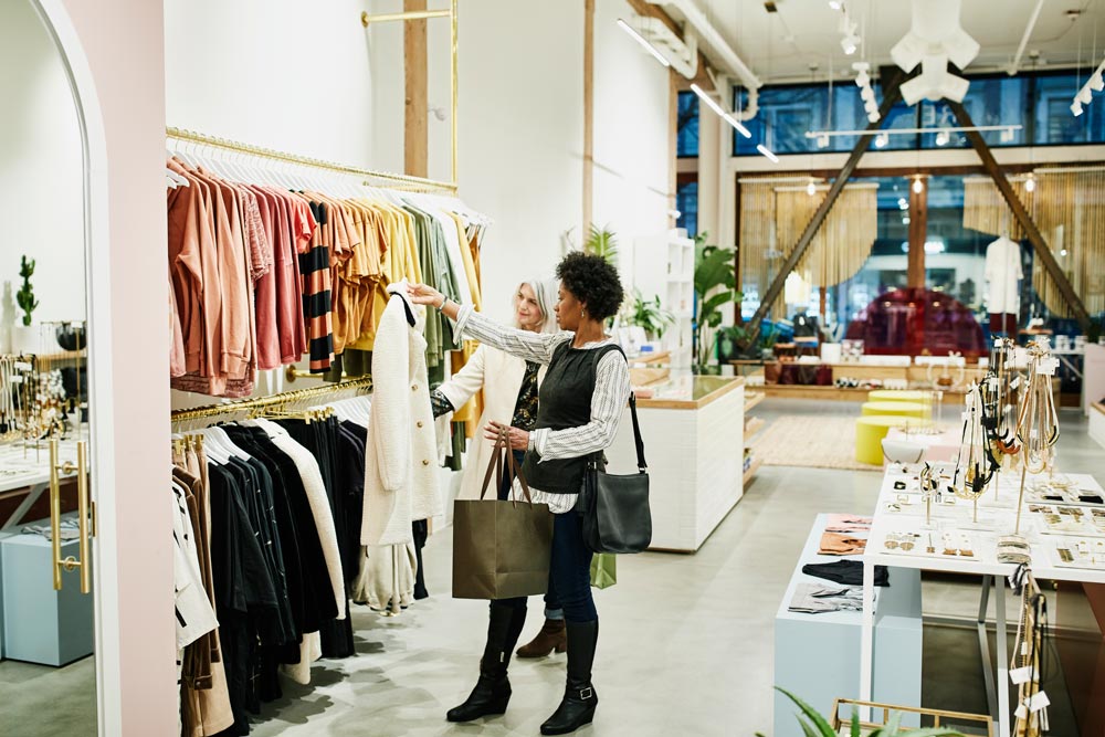 Kund i butik som letar kläder